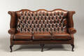 Chesterfield stil. Sofa betrukket med knapsyet brun læder