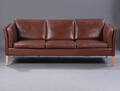 Dansk møbelproducent. Fritstående tre-pers. sofa, betrukket med brun læder