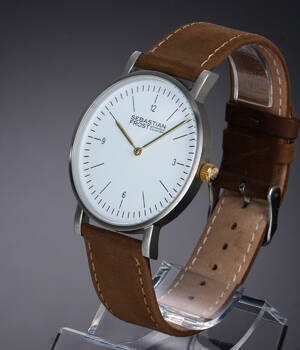 Sebastian Frost. Herreur i stål med hvid skive og original rem og spænde, 2010erne