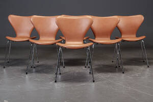 Arne Jacobsen. Et sæt på seks Syver stole med cognacfarvet calvados læder. 6