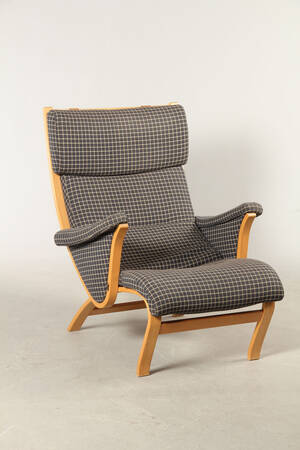 Dansk møbelproducent. Højrygget lænestol af formspændt bøg.