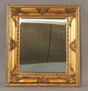 Spejl i ramme af guldbemalet træ.